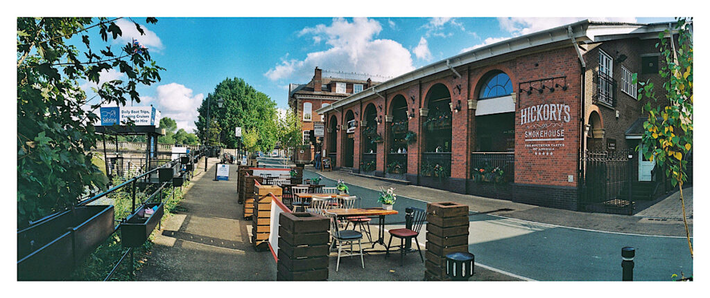 Colour photograph of a entertainment hub alongside a river