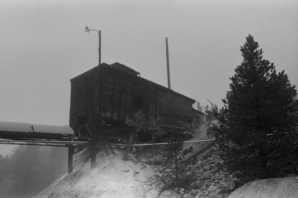 moody image of black mining building on a cliff