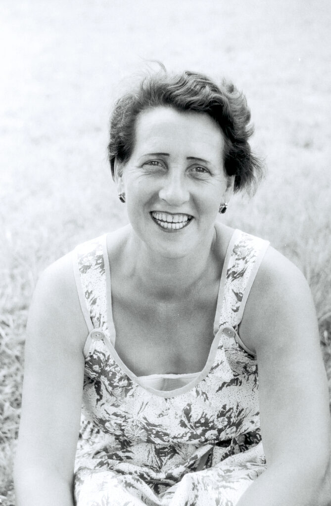 Black-and-white portrait of a smiling woman.