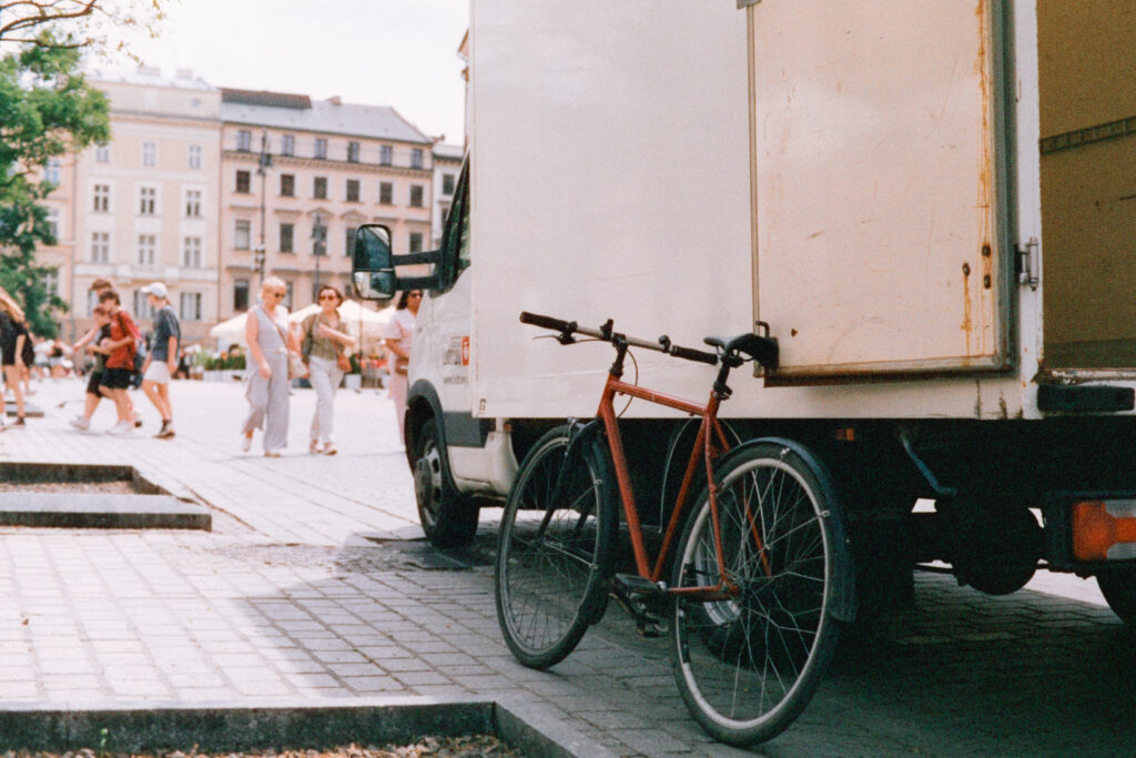 Bicycle leaning against a truck in the main square of Krakow