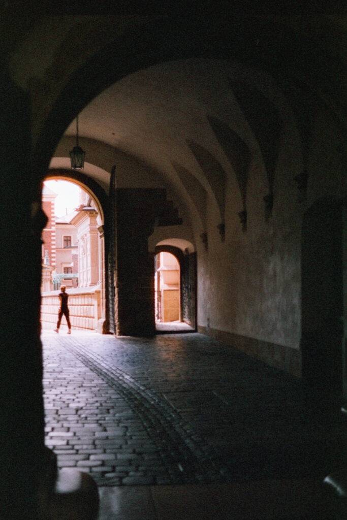 A dark arched tunnel with a single figure