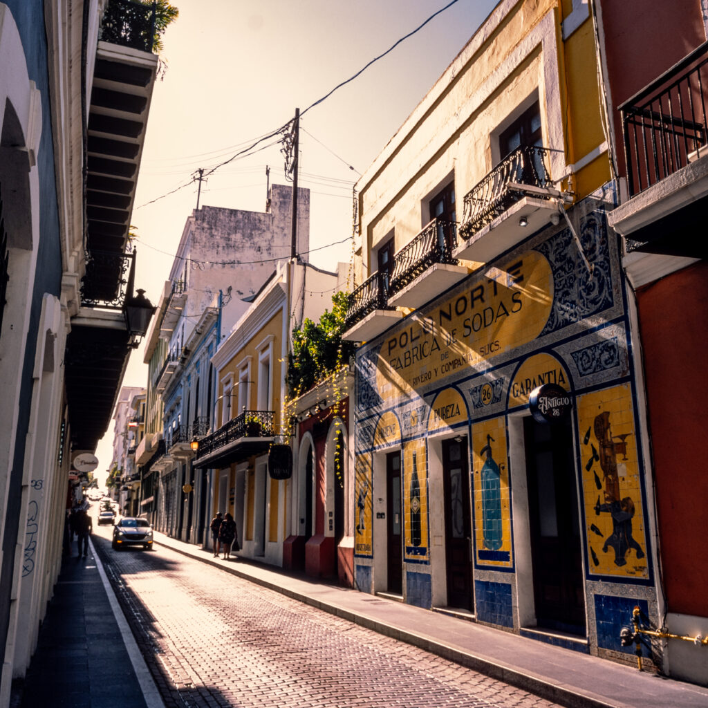 Narrow street with tall buildings in sunlight