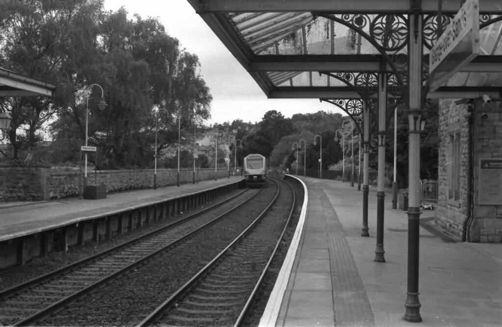 a railway station with a train in the distance