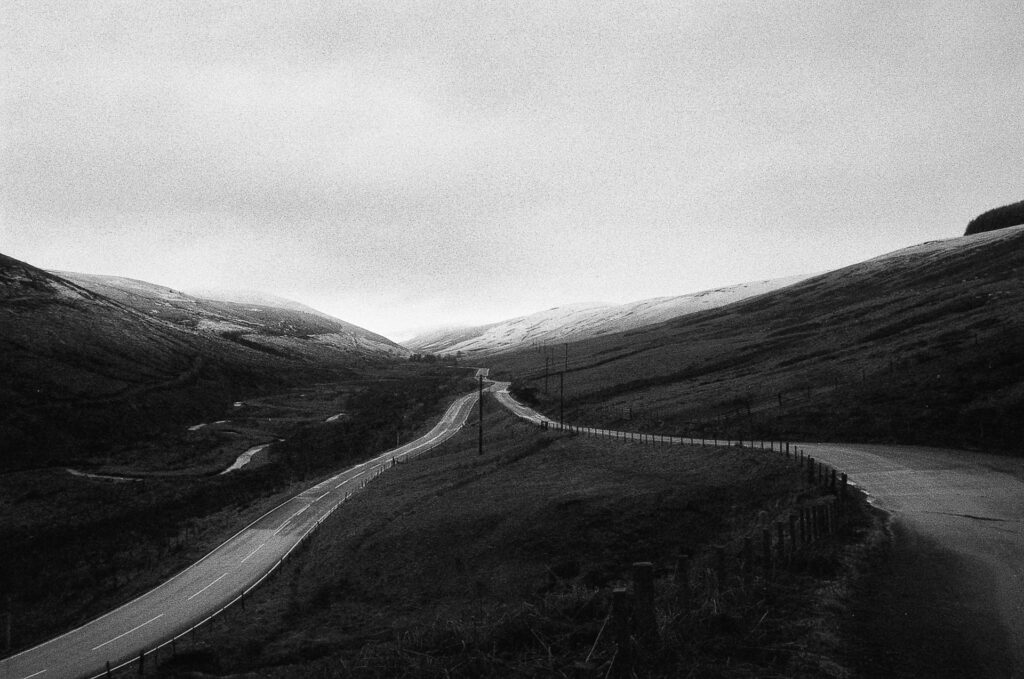 Dark Landscape Showing Two Roads Converging In A Valley 