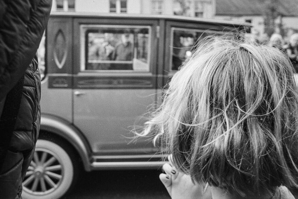 Rear View Of Girl Looking At Vintage Car With Her Hand To Mouth