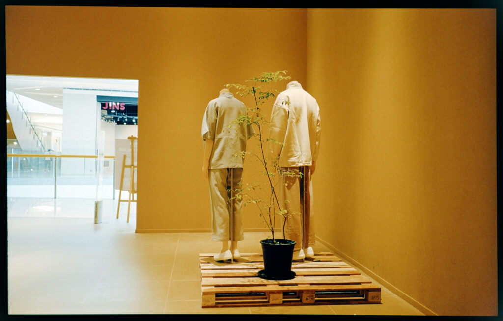 2 mannequins in a yellow painted room inside a shopping mall.