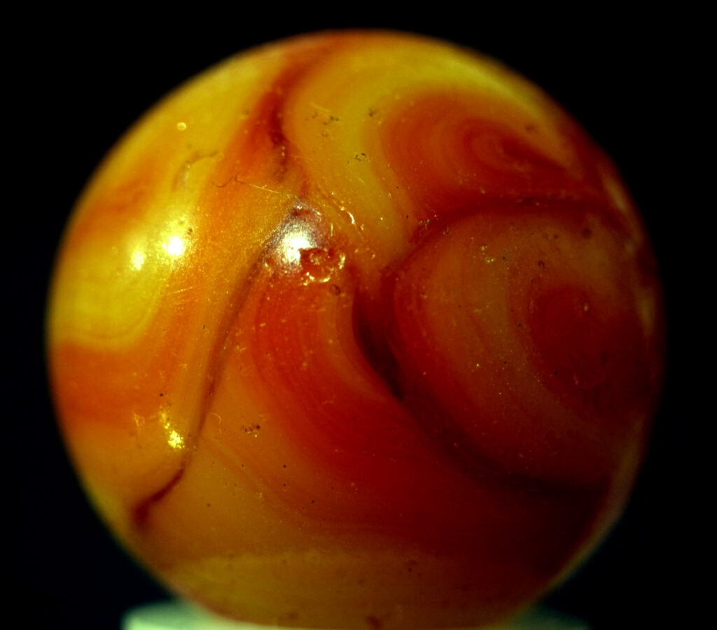 A swirlie orange planetoid marble