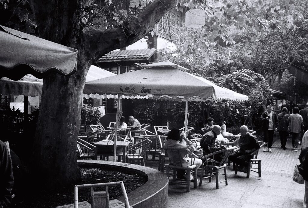 People sat around bamboo tables talking and drinking tea.