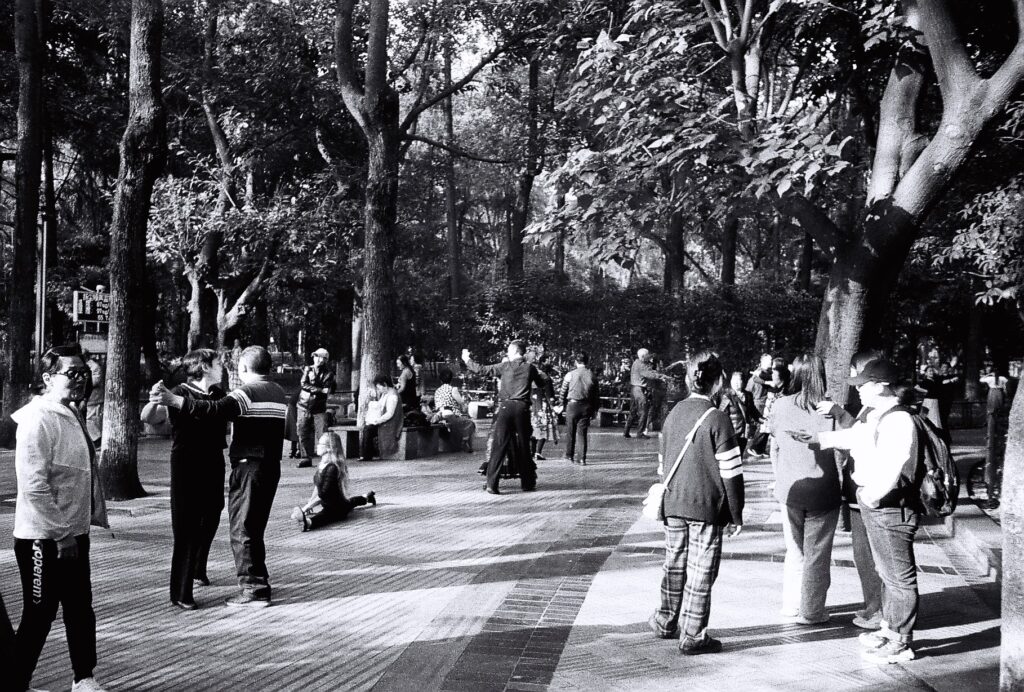 An open space with many people, some of whom are dancing.