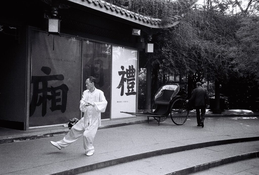 A man dressed in white doing Tai Chi.