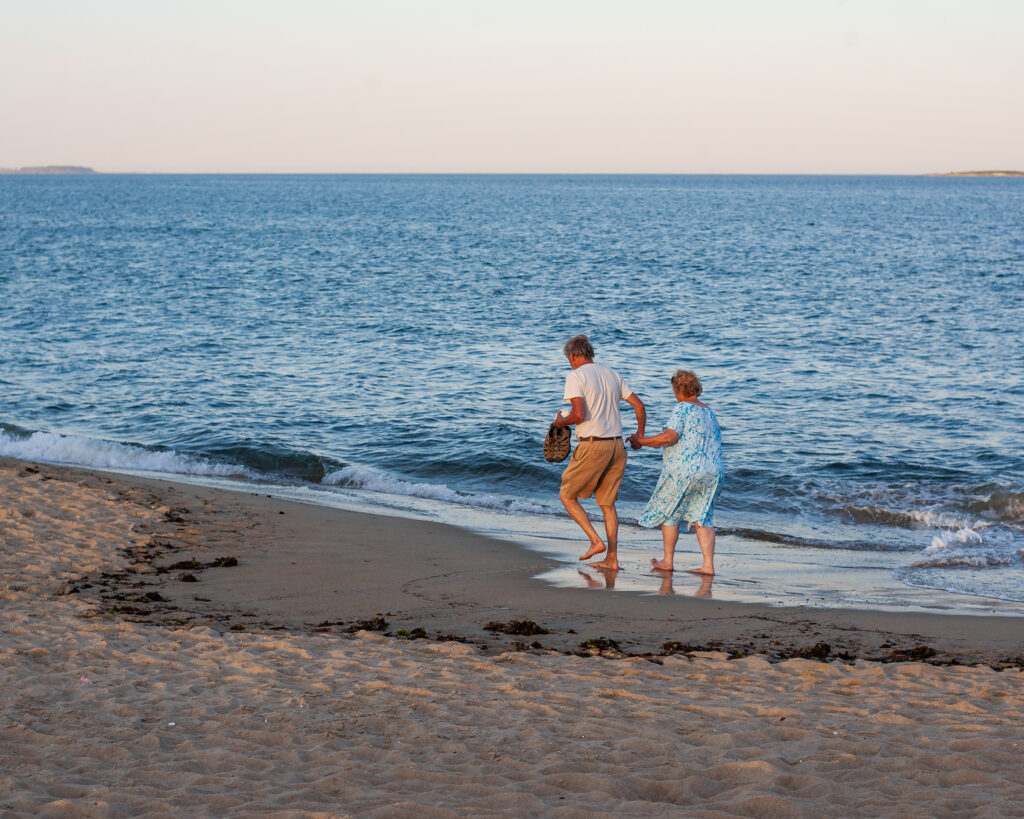 Older couple holding hands, walking