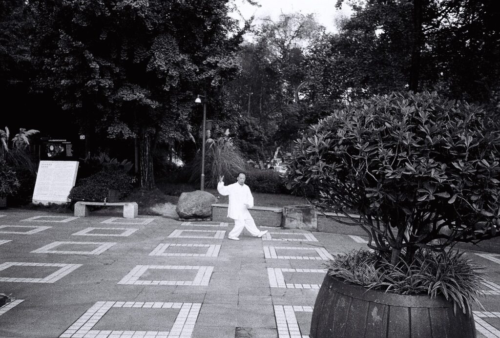 A man wearing white doing Tai Chi.