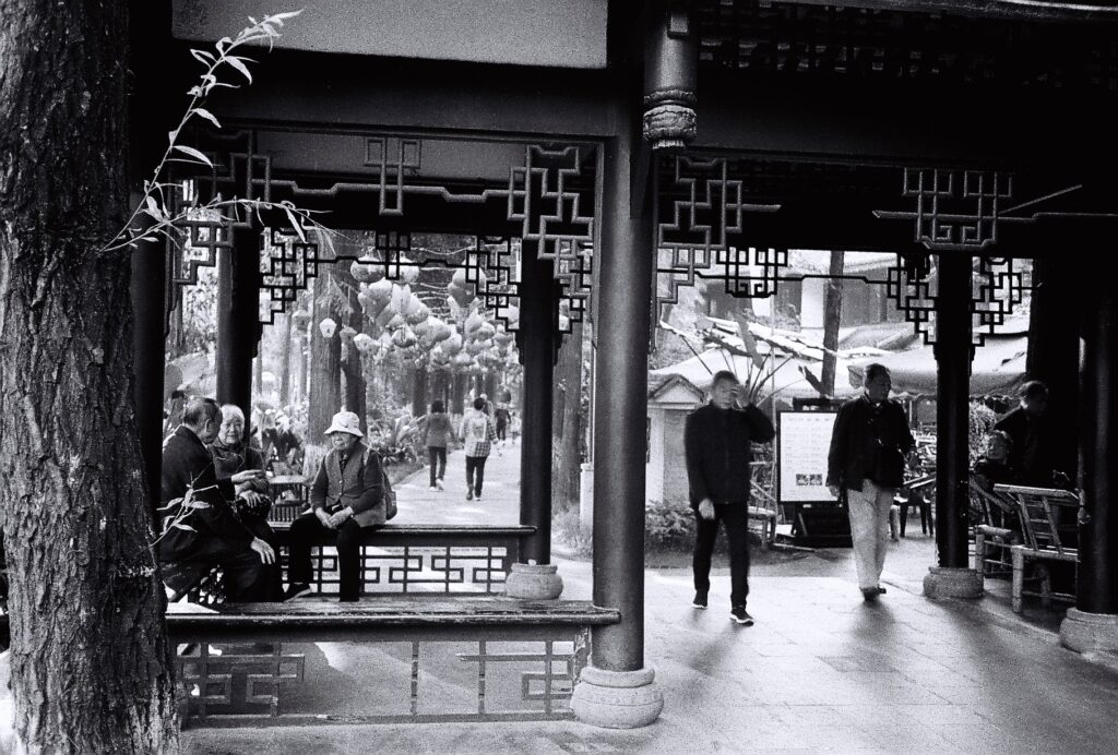 Three old people sat chatting in a pagoda.