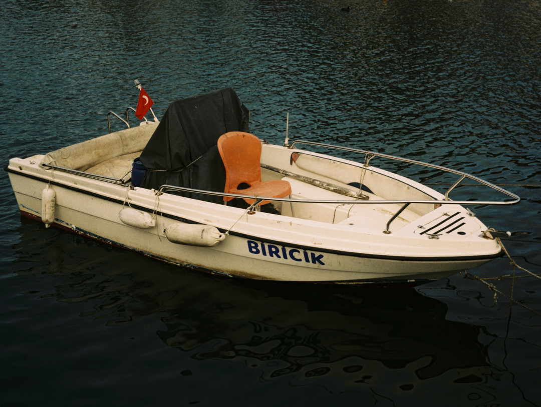 Small boat with a plastic chair on it