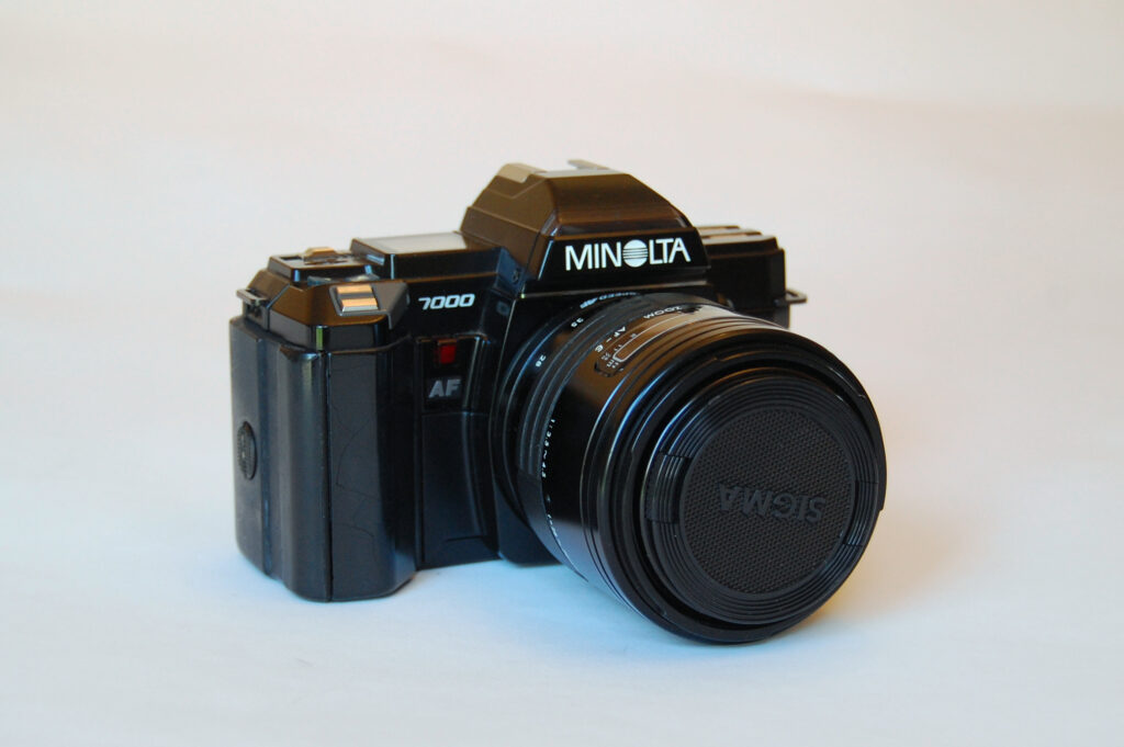 A Minolta Maxxum 7000 with a Sigma lens on a white background