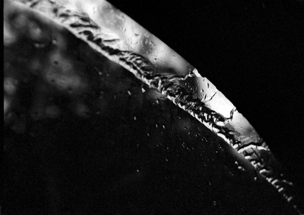 Rain running up the passenger window as we travel down the highway