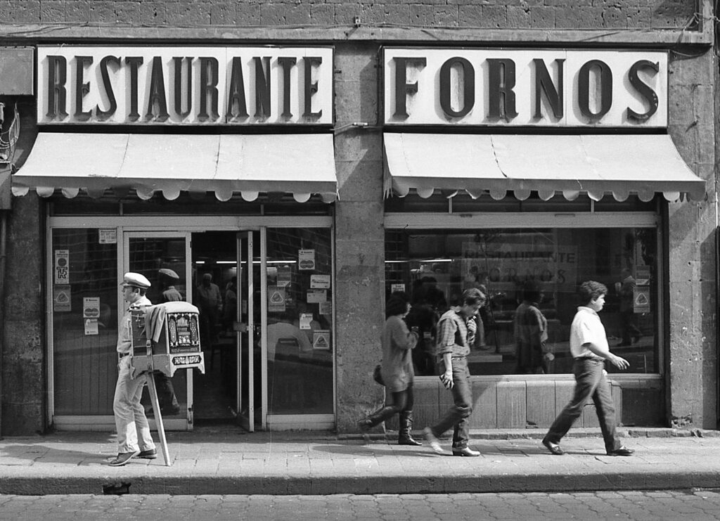 Restaurant on Isabel la Católica Street in the Historic Center of Mexico City. 1991. Notice the Organ Grinder playing his instrument at the entrance to the Restaurant. (These musicians use German organs from the early 20th century)