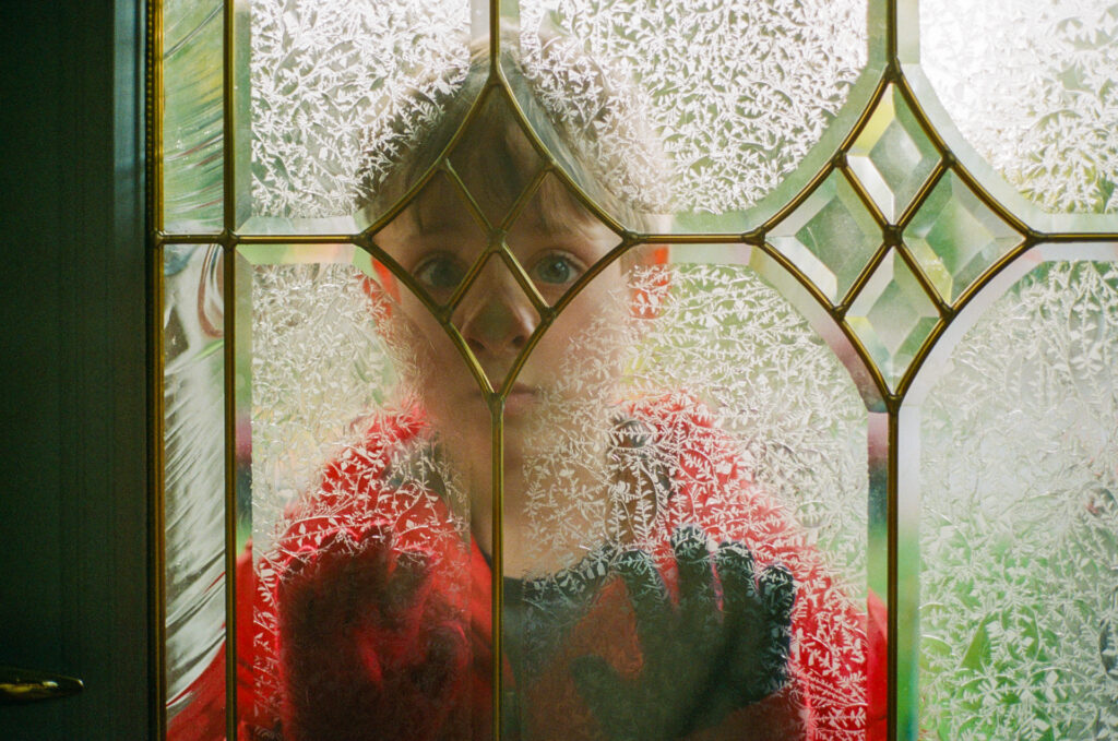 Boy behind glass door