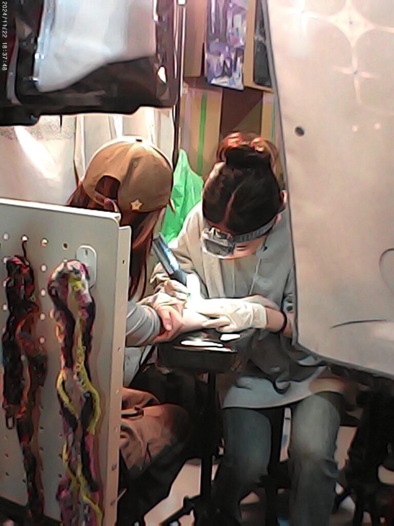 A woman receiving a tattoo at the Taipei art book fair.