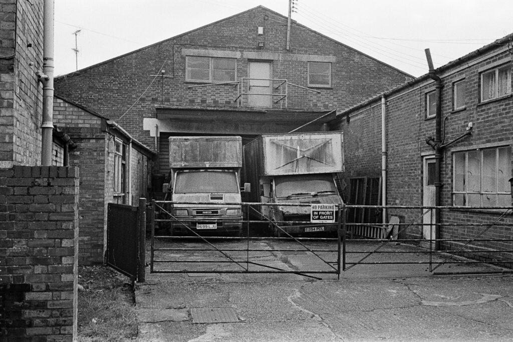 A couple of old trucks parked in a yard.