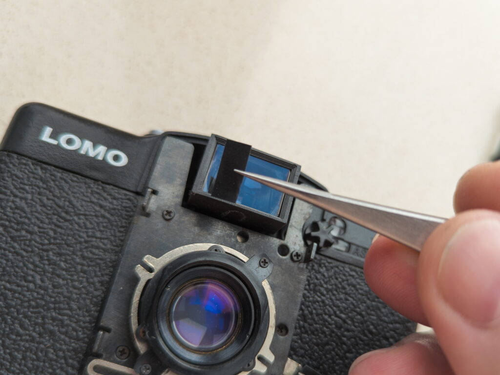 Installing non-transparent stickers to mask the viewfinder of the Lomo LC-A+ for the new frame format