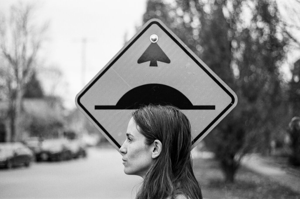 Woman standing by road sign